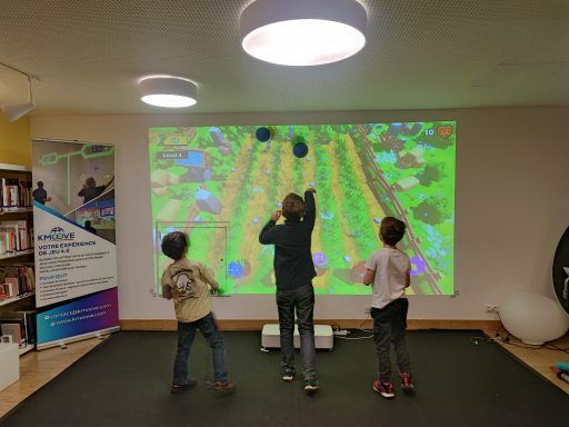 Enfants s'amusant avec un ballon devant le mur interactif